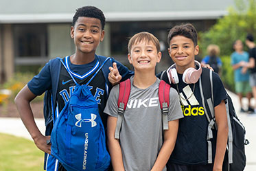 Three students standing outside together. Links to Gifts That Pay You Income
