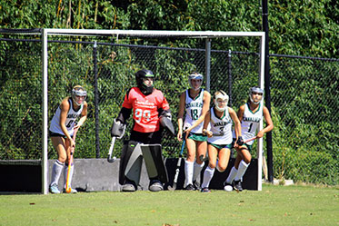 Students playing field hockey. Links to Gifts of Appreciated Securities