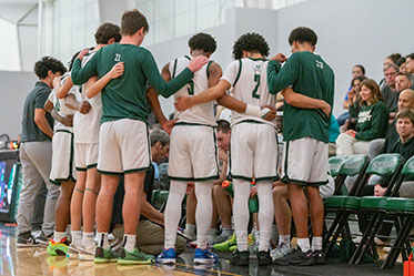 The boys basketball team in a huddle. Links to Closely Held Business Stock
