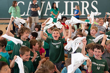Students cheering at a pep rally. Links to Gifts of Real Estate
