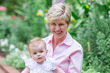 Emily Oliver holding a baby in her lap. Link to Emily Oliver's story.
