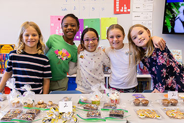 A group of girls working a bakesale together. Links to Gifts of Cash, Checks, and Credit Cards